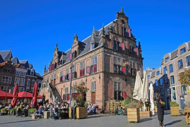 Nijmegen (grote markt), Hollanda - 27 Şubat. 2022: Güneşli bir günde kafeler, restoranlar ve eski ortaçağ binalarıyla dolu işlek pazar meydanını görmek