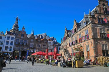 Nijmegen (grote markt), Hollanda - 27 Şubat. 2022: Güneşli bir günde kafeler, restoranlar ve eski ortaçağ binalarıyla dolu işlek pazar meydanını görmek