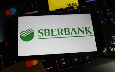 Viersen, Almanya - 9 Mart. 2022: Cep telefonu ekranını Rus sberbank logosuyla bilgisayar klavyesinde görüntüle