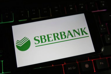 Viersen, Almanya - 9 Mart. 2022: Cep telefonu ekranını Rus sberbank logosuyla bilgisayar klavyesinde görüntüle