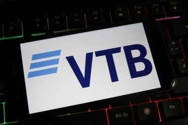 Viersen, Almanya - 9 Mart. 2022: Cep telefonu ekranını Rus VTB bankasının logosuyla bilgisayar klavyesinde görüntüle