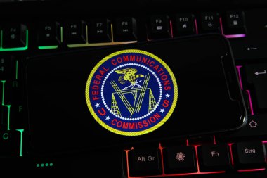 Viersen, Almanya - 9 Mart. 2022: Cep telefonu ekranının kapatılması ve bizim bilgisayar klavyesinde federal haberleşme komisyonumuzun logosu