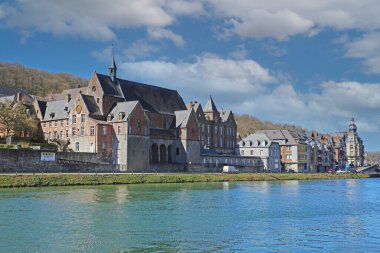 Dinant, Belçika - 9 Mart. 2022: Ortaçağ hükümetinin mali işler müdürü mavi gökyüzüne, kabarık bulutlara yardım ediyor