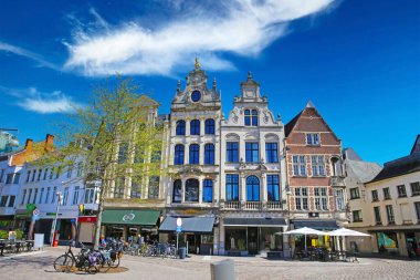 Yalancı (grote markt), Belçika - 9 Nisan. 2022: Ortaçağ binalarının pazar meydanında insanların kafelerin önünde oturduğu manzaralar