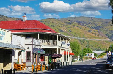 Clyde, Yeni Zelanda - 9 Aralık. 2013: Tarihi ahşap binalar, Dunstan ev mirası oteli, tepeler, mavi gökyüzü