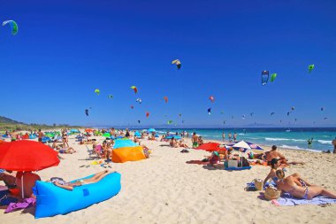 Tarifa, (Costa de la luz, Playa de Bolonia), İspanya - Haziran, 18. 2016: İnsanların güneşlendiği İspanyol sahnesi, uçurtma sörfçüleri, Atlantik okyanus dalgaları, açık mavi gökyüzü