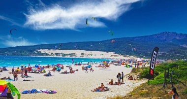 Tarifa, (Costa de la luz, Playa de Bolonia), İspanya - Haziran, 18. 2016: Güzel doğal kalabalık göl kumsalı, uçurtma sörfçüleri, kum tepesi, mavi gökyüzü
