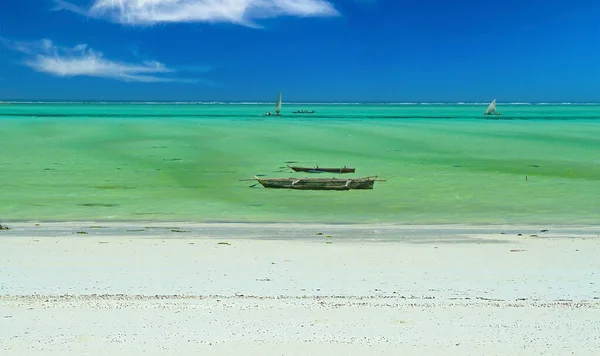 美しい空の無人島の明るい白い砂浜 ターコイズグリーンの浅い穏やかな海 伝統的な木製のダウボート 澄んだ青い空の地平線 Zanzibar Indian Ocean — ストック写真