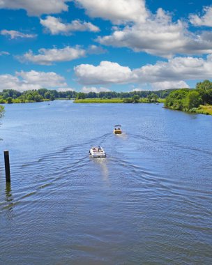 Güzel, huzurlu Hollanda göl manzarası, 2 motorlu spor tekne, yeşil orman, mavi yaz gökyüzü - Leukermeer, Hollanda