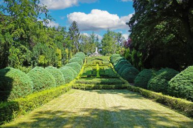 Beautiful old green abbey monastery garden park in summer, holy heart of jesus statue on hill, boxwood hedges forming latin christian cross  - Steyl (Venlo Tegelen), Netherlands