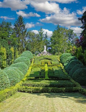 Beautiful old green abbey monastery garden park in summer, holy heart of jesus statue on hill, boxwood hedges forming latin christian cross  - Steyl (Venlo Tegelen), Netherlands