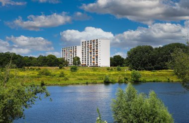 Venlo, Hollanda - 9 Temmuz. 2022: Güzel yeşil nehir Maas manzarası, nehir manzaralı iki ayrı modern deniz manzaralı konut evleri, mavi yaz gökyüzü