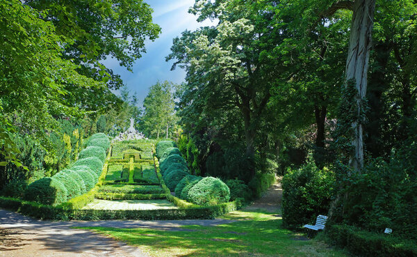 Beautiful old green abbey monastery garden park in summer, holy heart of jesus statue on hill, boxwood hedges forming latin christian cross  - Steyl (Venlo Tegelen), Netherlands