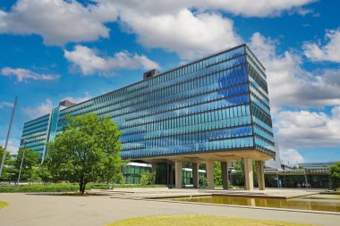 TU Eindhoven (technical university), Netherlands - July 19. 2022: Modern architecture glass facade building with sky clouds reflection on dutch campus
