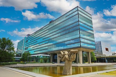 TU Eindhoven (technical university), Netherlands - July 19. 2022: Modern architecture glass facade building with sky clouds reflection on dutch campus
