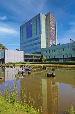 TU Eindhoven (technical university), Netherlands - July 17. 2022: Modern architecture auditorium building with idyllic water pond on dutch campus