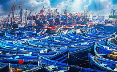 Countless old blue wooden traditional fishing boats crammed together in overcrowded no space full north african harbor  - Essaouira, Morocco