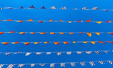 Many lines rows of isolated flag pennats chains garlands racing symbol against clear blue cloudless summer sky - Zandvoort, Netherlands