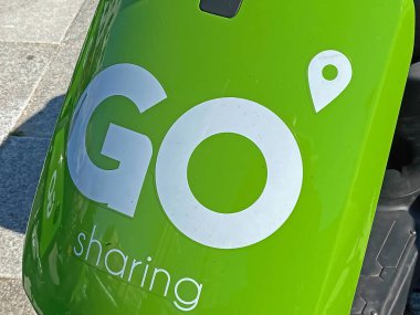 Zandvoort, Netherlands - August 12. 2022: Closeup of green white GO Sharing Company logo lettering on electric scooter front