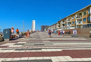 Zandvoort, Netherlands - August 12. 2022: Beautiful colorful dutch north sea side promenade in coast town, waterfront homes, blue summer sky