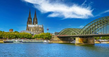 Beautiful river rhine river skyline, medieval gothic dome, Hohenzollern bridge, dramit blue summer sky - Cologne, Germany (focus on center of upper bridge)