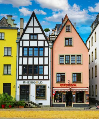 Cologne (Buttermarkt), Germany - July 9. 2022: Beautiful colorful medieval german very narrow houses, blue summer sky
