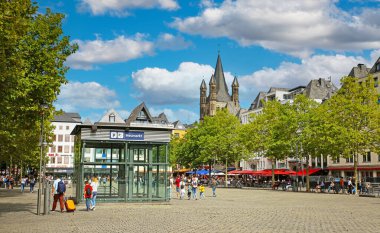 Cologne (Heumarkt), July 9. 2022:  Beautiful market square in historical city center, church tower, blue sumer sky, fluffy cumulus clouds