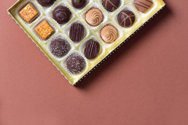 Açık bir kutu ve çeşitli çikolatalar ile hafif arkaplan ve metin için boşluk