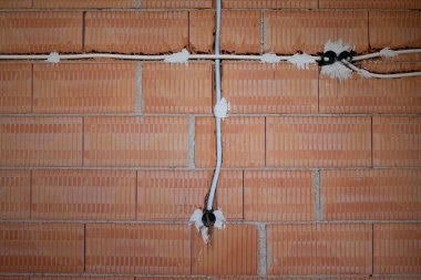 Yeni örülmüş bir duvarın arka planı ve dokusu. Duvarda yarıklar açılmış ve elektrik sistemi için kanallar çizilmiş..