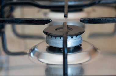 Close-up of a gas stove with no gas flowing out of it. The oven is turned off. The flame has gone out.