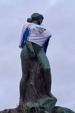 Helsinki, Finlandiya - 20 Şubat 2022: Buz hokeyi hayranları, Finlandiya 'nın Pekin 2022 Olimpiyatları' nda buz hokeyi dalında ilk altın madalyasını kazanmasından sonra Havis Amanda heykelini Finlandiya milli buz hokeyi takımı formasıyla dekore ettiler..