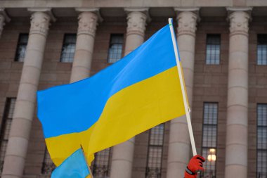 Helsinki, Finlandiya - 22 Şubat 2022: Ukrayna 'nın Ukrayna bayrağını Finlandiya Parlamentosu önünde taşıyan Rusya' nın askeri saldırısına karşı düzenlenen mitingde gösterici. 
