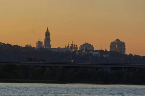 Prachtig uitzicht op Pechersk Lavra in Kiev bij zonsopgang. Een UNESCO werelderfgoed site in Oekraïne. Uitzicht vanaf rivier de Dniepr. Ruimte voor tekst. Stockafbeelding