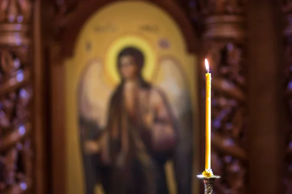 Красивая одна свеча в темной церкви, идея уважать того, кого любишь, помнить и исполнять желания, на заднем плане — стоковое фото