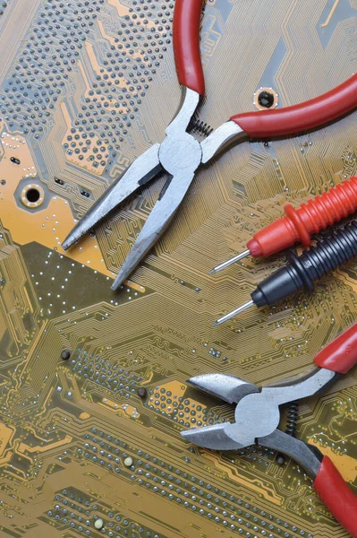 the electronics repair tool lies on the motherboard from the computer. close-up.