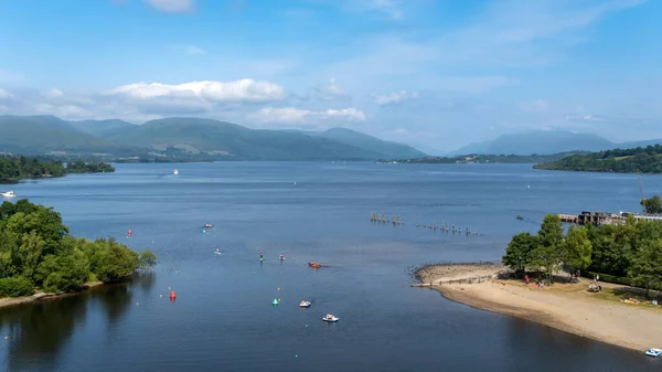 stock image View over Loch Lomond from Lomond shores on a sunny summer day in Scotland, with people participating in water sports, Balloch, Scotland