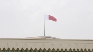 Katar 'ın Al-Adaam Ulusal Bayrağı, Katar' ın Doha kentindeki Amiri Diwan Parlamento Binası 'nın üzerinde dalgalanıyor.