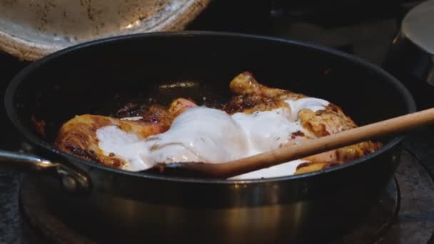 木製スプーンでストーブの上で調理赤タイ鶏カレーにココナッツミルクを攪拌 — ストック動画