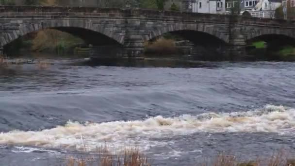 スコットランドの冬にニュートン スチュワートのクリー橋で堰の上を流れる川のクレイ — ストック動画