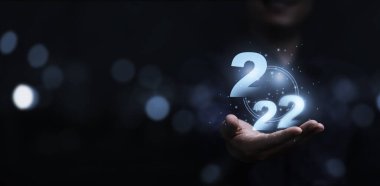 Sanal 2022 numaraya sahip iş adamı mavi arka planı ve Mutlu Noeller ve mutlu yıllar konsepti için kopyalama alanı tutuyor..