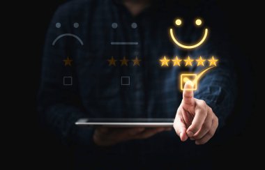 Müşteri tableti tutuyor ve kullanım ürünü ve servis kavramından sonra değerlendirmek için sanal gülen yüz işaretine dokunuyor.