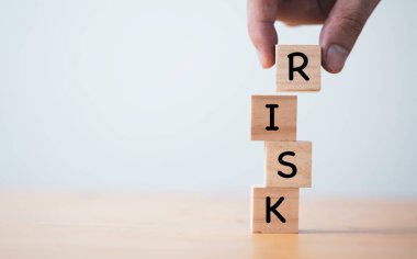 Risk yönetimi konsepti için el koymak ve tahta küp bloğu istiflemek.