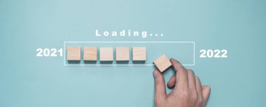 2021 'den 2022' ye kadar olan yükleme sembolü için tahta blok yerleştirin ve geri sayım mutlu noeller yeni yıl konsepti.