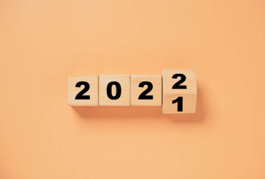2021 'den 2022' ye kadar tahta blok turuncu arka planda takla atıyor. Mutlu Noeller ve mutlu yıllar için hazırlık..