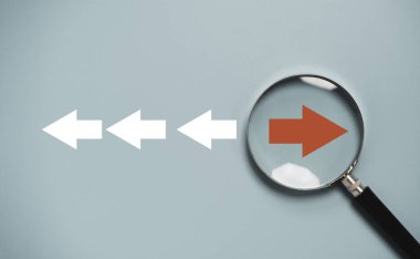 Büyüteç camının içindeki kırmızı ok ve odak noktası bozulması ve teknoloji dönüşümü kavramı için beyaz oktan farklı yön.