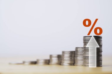 Faiz artışı ve ekonomik kar yatırımı büyüme konsepti için okla istiflenen paralarda kırmızı yüzde işareti.