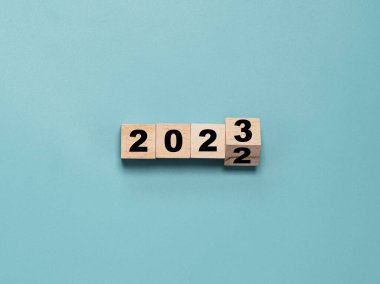 Değişiklik ve hazırlık için 2022 ile 2023 yılları arasında çeviren tahta blok küpü Mutlu Noeller ve mutlu yıllar..