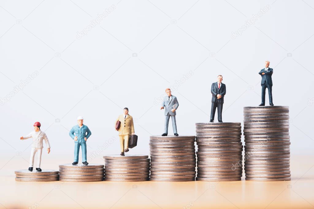 worker technician businessman and management miniature figure standing on different coins stacking for symbol of various income in each job level concept.