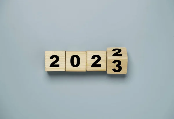 Değişiklik ve hazırlık için 2022 ile 2023 yılları arasında çeviren tahta blok küpü Mutlu Noeller ve mutlu yıllar..