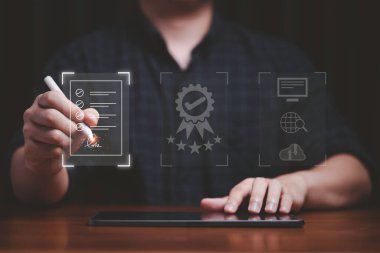Hand using electronic for signature to document on  virtual screen and document for online approve paperless quality assurance and ERP management concept.